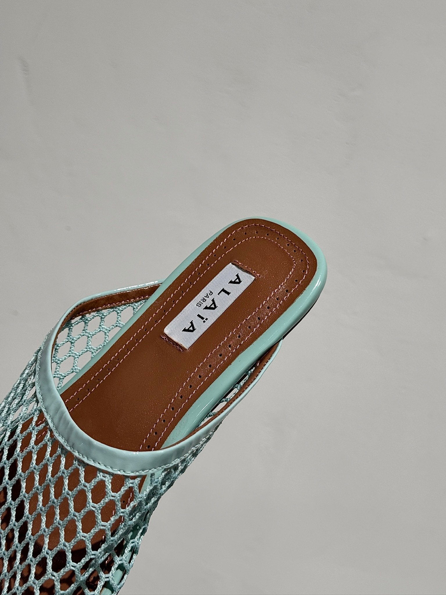 ALAIA FLAT MULES IN LIGHT BLUE MESH FISHNET